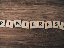 Las fichas de Scrabble deletrean "PINTEREST" en una superficie de madera, resaltando el impacto de la plataforma en el marketing online.