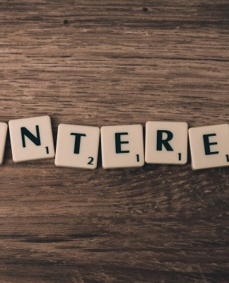 ¿Qué aporta Pinterest al marketing online? Las fichas de Scrabble deletrean "PINTEREST" en una superficie de madera, resaltando el impacto de la plataforma en el marketing online.