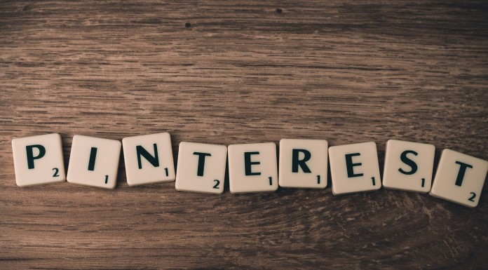 Las fichas de Scrabble deletrean "PINTEREST" en una superficie de madera, resaltando el impacto de la plataforma en el marketing online.