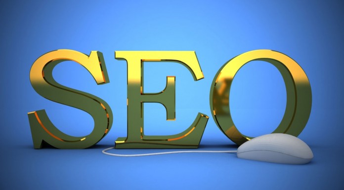 Las letras 3D doradas "SEO" se destacan orgullosamente sobre un fondo azul, con un mouse de computadora conectado por un cable en el frente, simbolizando la importancia del contenido y las estrategias para un posicionamiento efectivo.