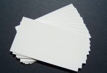 Una pila de tarjetas de presentación blancas en blanco, perfectas para la marca, se extiende sobre una superficie oscura.