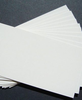 Una pila de tarjetas de presentación blancas en blanco, perfectas para la marca, se extiende sobre una superficie oscura.