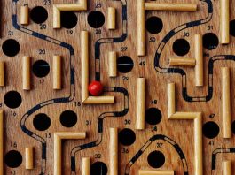 En nuestra plataforma de comercio electrónico se encuentra disponible un juego de laberinto de madera con caminos y agujeros numerados. Una bola roja reposa en el laberinto, cerca del número 36, lista para que la recorras a través de la tienda online.