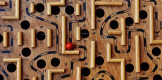 En nuestra plataforma de comercio electrónico se encuentra disponible un juego de laberinto de madera con caminos y agujeros numerados. Una bola roja reposa en el laberinto, cerca del número 36, lista para que la recorras a través de la tienda online.