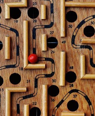 En nuestra plataforma de comercio electrónico se encuentra disponible un juego de laberinto de madera con caminos y agujeros numerados. Una bola roja reposa en el laberinto, cerca del número 36, lista para que la recorras a través de la tienda online.