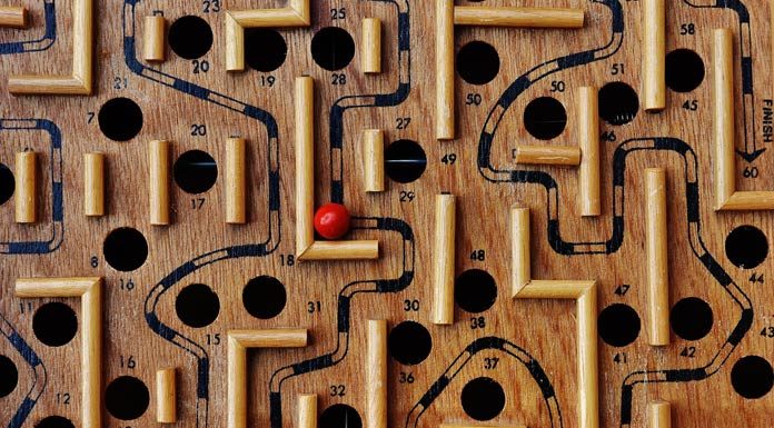 En nuestra plataforma de comercio electrónico se encuentra disponible un juego de laberinto de madera con caminos y agujeros numerados. Una bola roja reposa en el laberinto, cerca del número 36, lista para que la recorras a través de la tienda online.