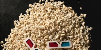 Una pila de palomitas de maíz con un par de gafas 3D rojas y azules encima te invita a adentrarte en un mundo donde las animaciones 3D cobran vida.