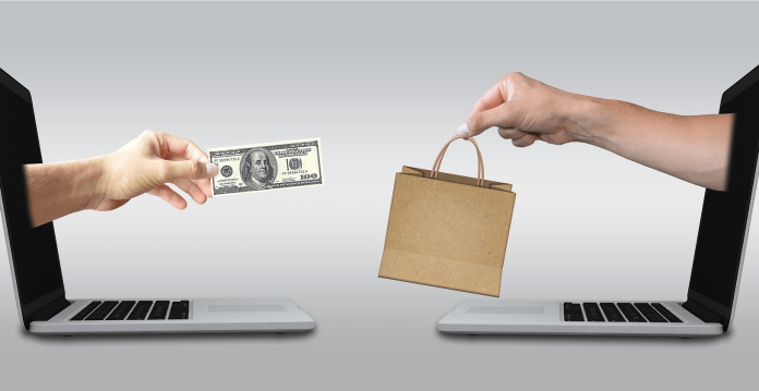Dos pantallas de portátiles con manos que emergen; una sostiene un billete de dólar y la otra una bolsa de la compra. Esta escena captura la esencia de las compras y el marketing online, y simboliza cómo las estrategias de promoción llegan a los clientes sin esfuerzo en la era digital.