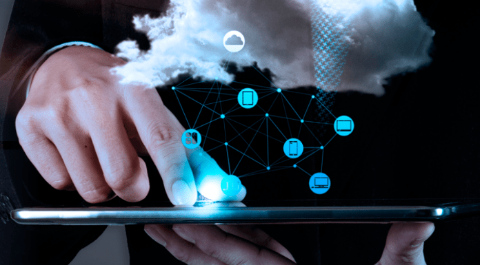 Los beneficios de la seguridad informática Una persona interactúa con una tableta que muestra una nube digital e íconos de red, que simbolizan la seguridad y los beneficios de la tecnología de computación en la nube.