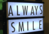 Una caja de luz que muestra el mensaje "SONRÍE SIEMPRE" en letras mayúsculas.