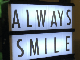 Una caja de luz que muestra el mensaje "SONRÍE SIEMPRE" en letras mayúsculas.