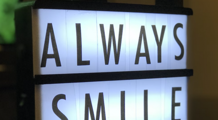 Cómo conseguir más pacientes en una clínica dental Una caja de luz que muestra el mensaje "SONRÍE SIEMPRE" en letras mayúsculas.