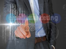 Persona con traje que señala una interfaz virtual con las palabras "marketing por correo electrónico" e íconos flotando alrededor.