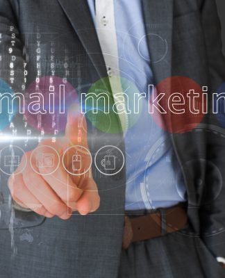 Persona con traje que señala una interfaz virtual con las palabras "marketing por correo electrónico" e íconos flotando alrededor.