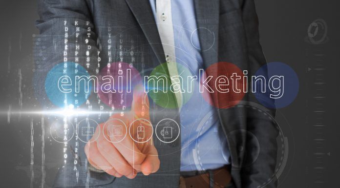 Persona con traje que señala una interfaz virtual con las palabras "marketing por correo electrónico" e íconos flotando alrededor.